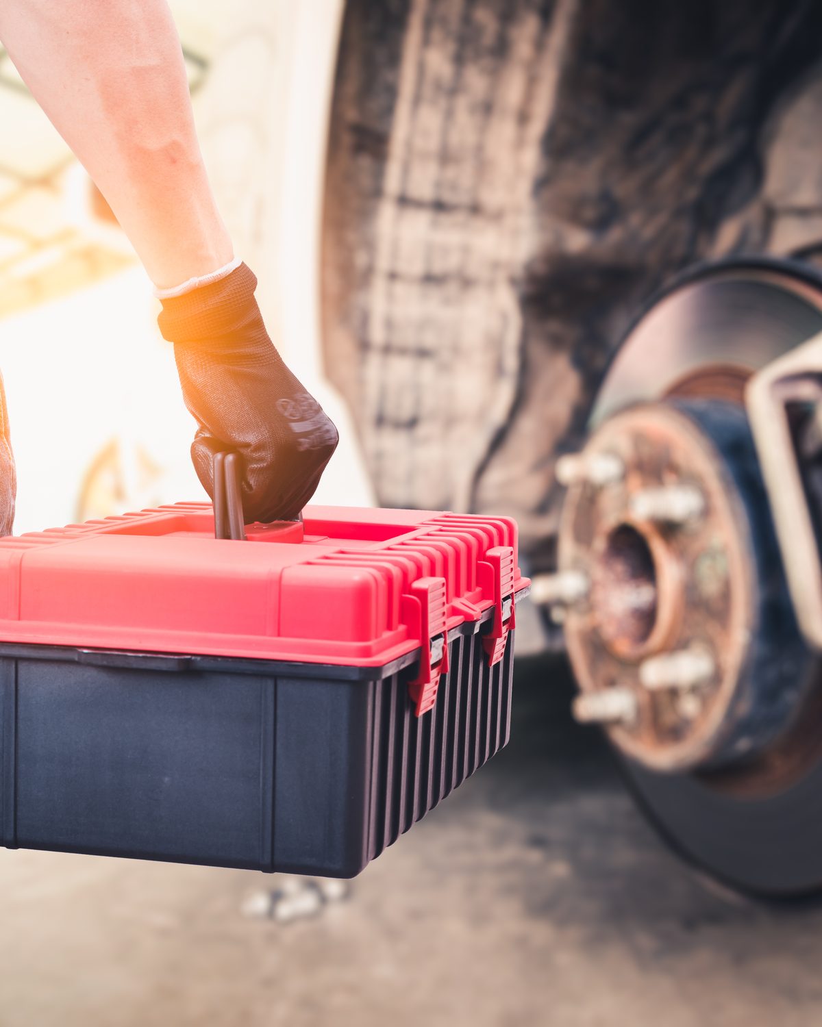 A mobile mechanic working on a car in a driveway